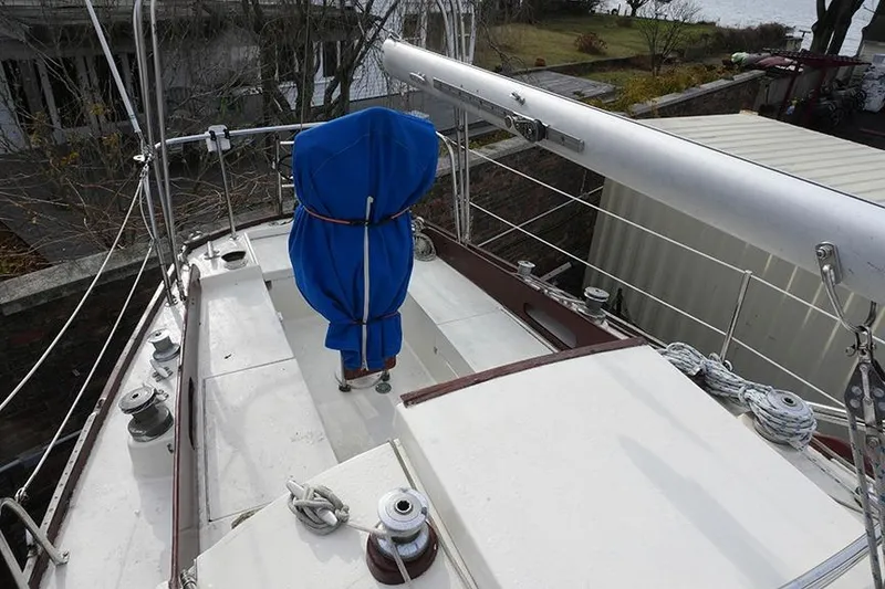 Slide: The Image of 1978 Bristol 29.9 sailboat deck with blue-covered mast, docked outdoors. - 11