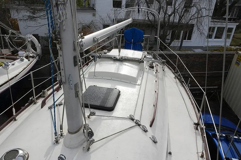 Slide: The Image of 1978 Bristol 29.9 sailboat deck with mast and rigging, docked near buildings. - 19