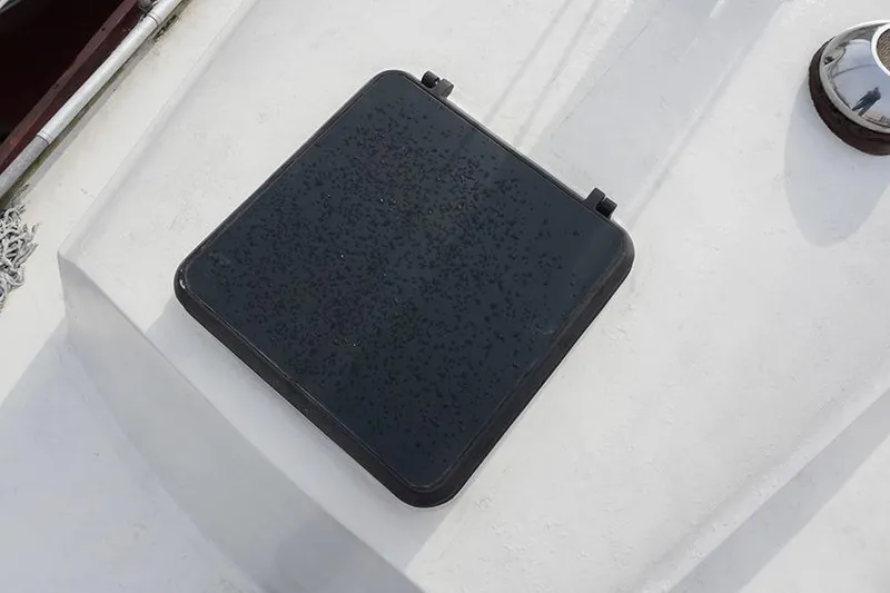 Slide: The Image of Hatch on 1978 Bristol 29.9 sailboat deck, featuring a black cover. - 25