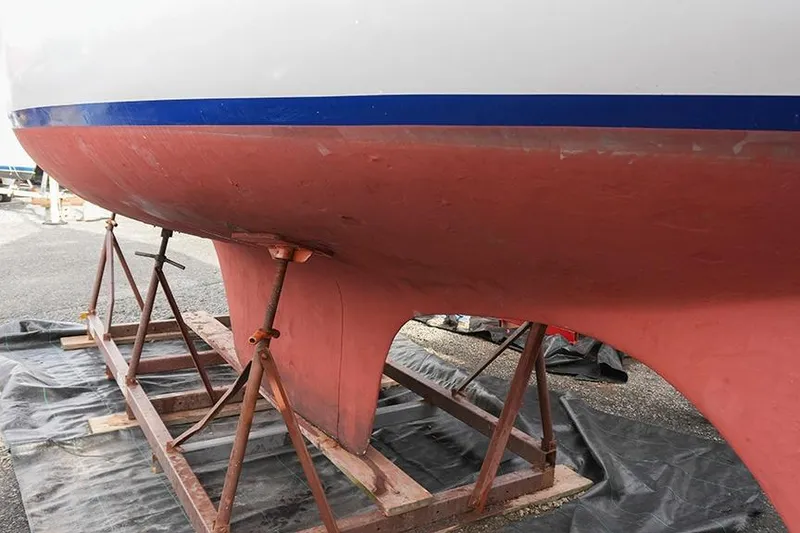 Slide: The Image of 1978 Bristol 29.9 sailboat hull on stands, showcasing red and white design. - 3