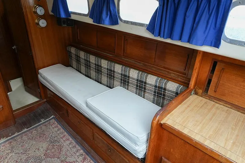 Slide: The Image of Interior of a 1978 Bristol 29.9 sailboat with wooden paneling and blue curtains. - 31