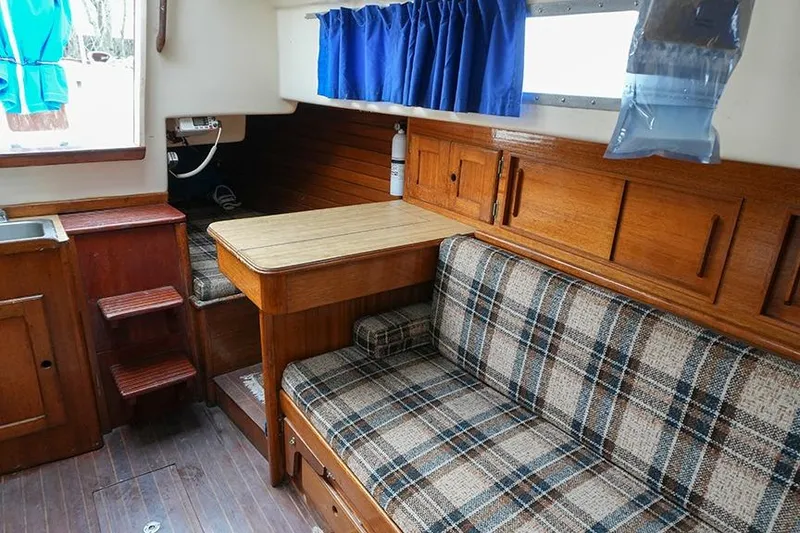 Slide: The Image of Interior of a 1978 Bristol 29.9 sailboat with plaid seating and wooden cabinetry. - 33