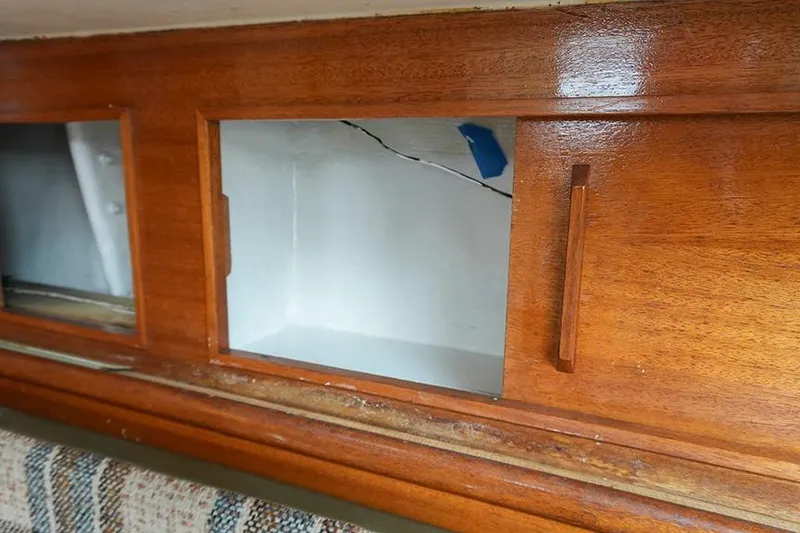Slide: The Image of Wooden interior cabinet of a 1978 Bristol 29.9 boat, featuring open compartments. - 38