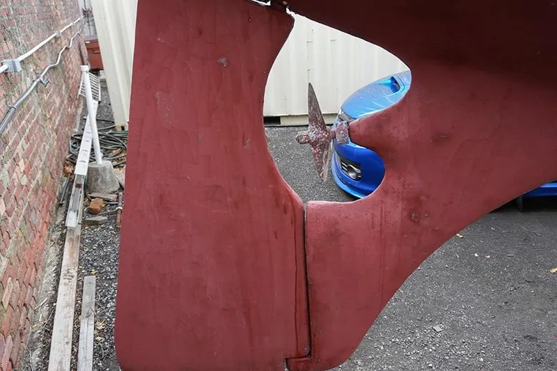 Slide: The Image of Damaged rudder of a 1978 Bristol 29.9 sailboat, with a blue car in the background. - 4