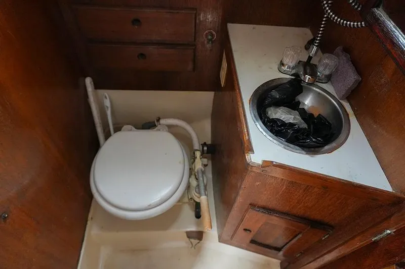 Slide: The Image of 1978 Bristol 29.9 yacht bathroom with toilet, sink, and wooden cabinetry. - 40