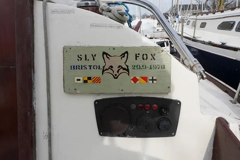 Slide: The Image of 1978 Bristol 29.9 sailboat with "Sly Fox" sign and nautical flags. - 41