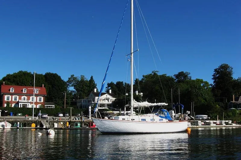 Slide: The Image of 1978 Bristol 29.9 sailboat docked in a scenic marina with clear blue skies. - 42