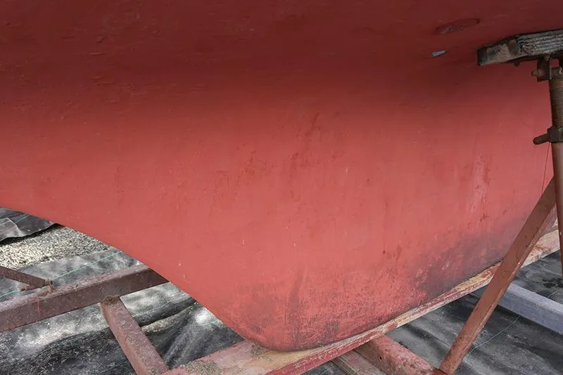 Slide: The Image of Red hull of a 1978 Bristol 29.9 sailboat on a stand. - 5