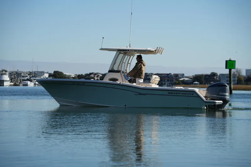 Slide: The Image of 2018 Grady-White Fisherman 236 boat cruising on calm water near coastal town. - 14