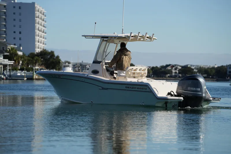 Slide: The Image of 2018 Grady-White Fisherman 236 boat cruising on calm water near buildings. - 16