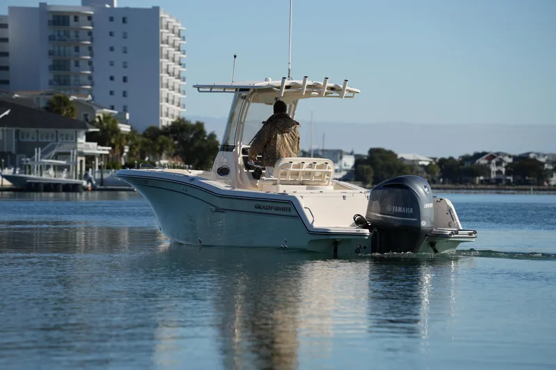 Slide: The Image of 2018 Grady-White Fisherman 236 boat cruising on calm water near urban shoreline. - 17