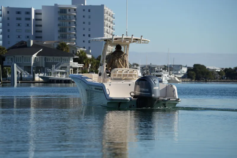 Slide: The Image of 2018 Grady-White Fisherman 236 boat cruising near waterfront buildings. - 18