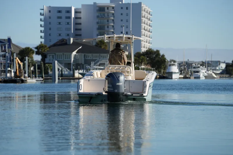 Slide: The Image of 2018 Grady-White Fisherman 236 boat cruising in a marina with buildings in the background. - 19