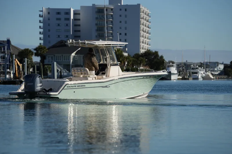 Slide: The Image of 2018 Grady-White Fisherman 236 boat cruising near waterfront buildings. - 22