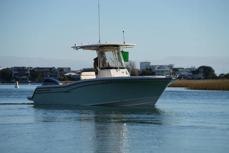 Slide: The Image of 2018 Grady-White Fisherman 236 boat cruising on calm water near shoreline. - 4