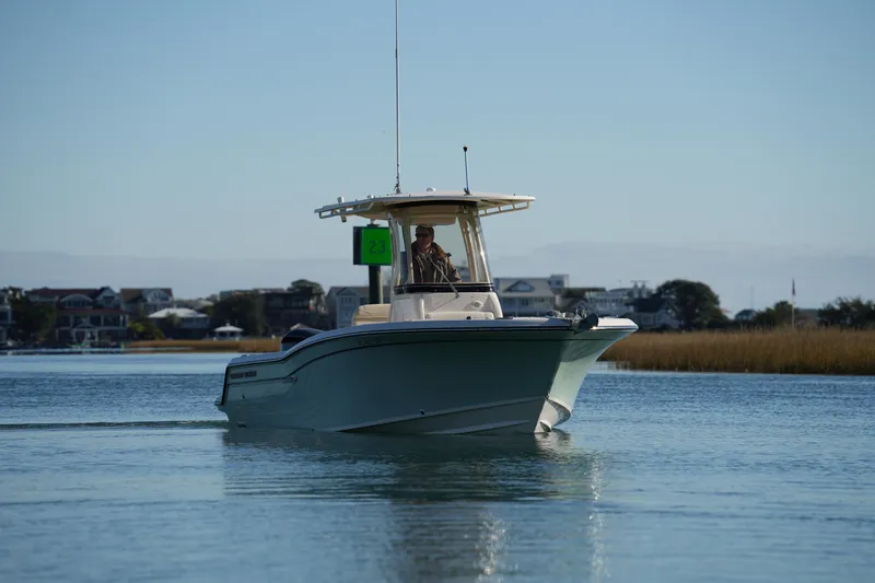 Slide: The Image of 2018 Grady-White Fisherman 236 boat cruising on calm water near shoreline. - 5