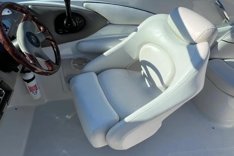 Slide: The Image of 2005 Crownline 226 LS boat interior with white captain's chair and wooden steering wheel. - 11