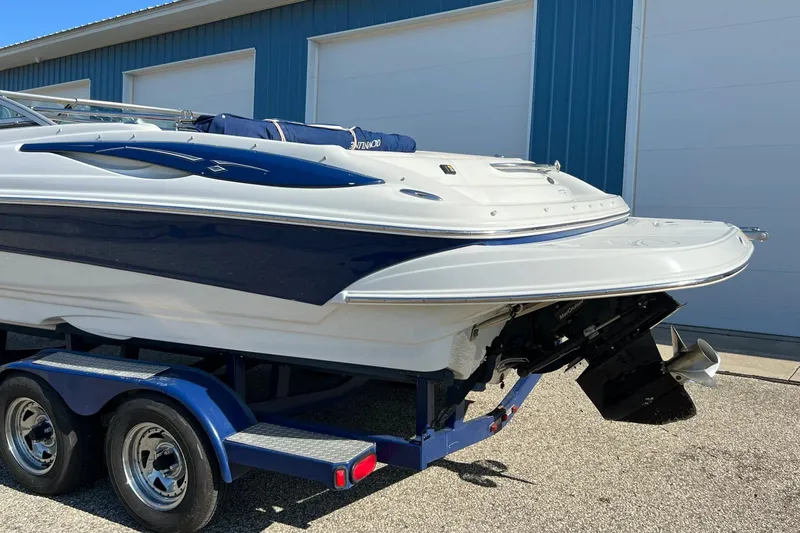 Slide: The Image of 2005 Crownline 226 LS boat on trailer, parked near blue building. - 16