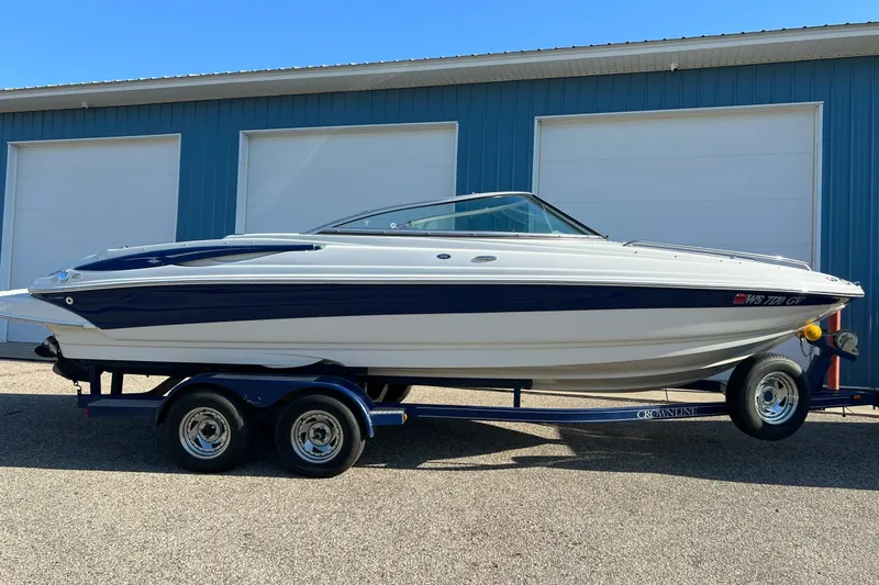 Slide: The Image of 2005 Crownline 226 LS boat on trailer, parked outside blue garage. - 5