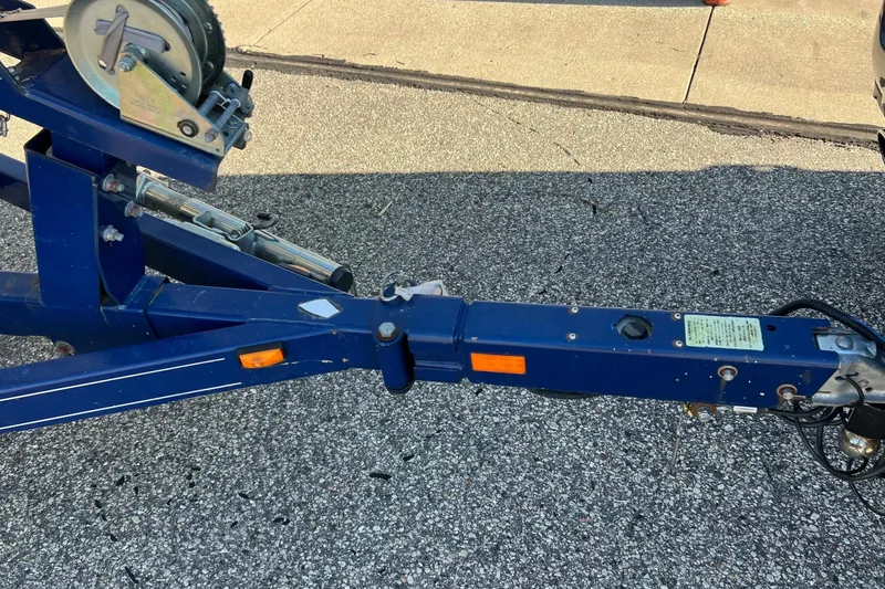 Slide: The Image of Blue boat trailer hitch for 2005 Crownline 226 LS on asphalt surface. - 6