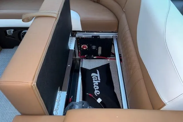 Slide: The Image of 2026 Tahoe Pontoon LTZ 2185 ELITE interior storage compartment with tan seating. - 28