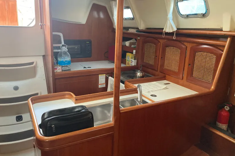 Slide: The Image of Interior of 2000 Beneteau Oceanis 361 sailboat, featuring a compact kitchen area. - 18