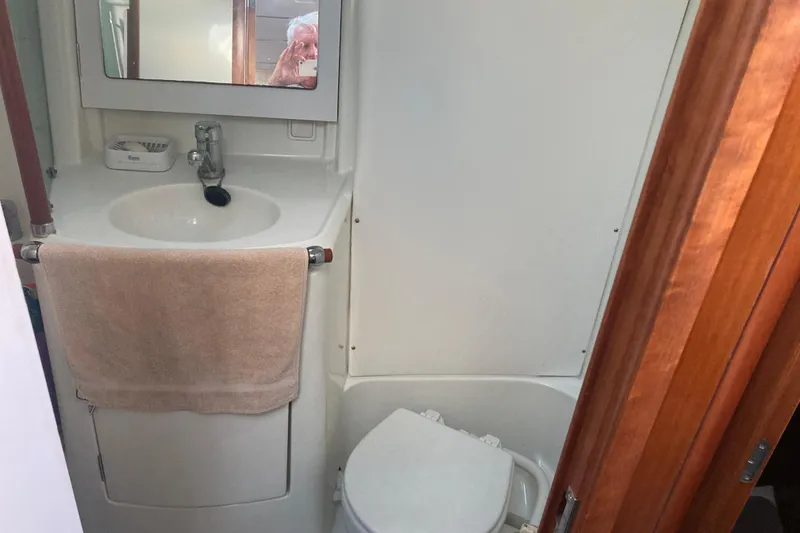 Slide: The Image of Bathroom interior of 2000 Beneteau Oceanis 361 yacht with sink, mirror, and toilet. - 21