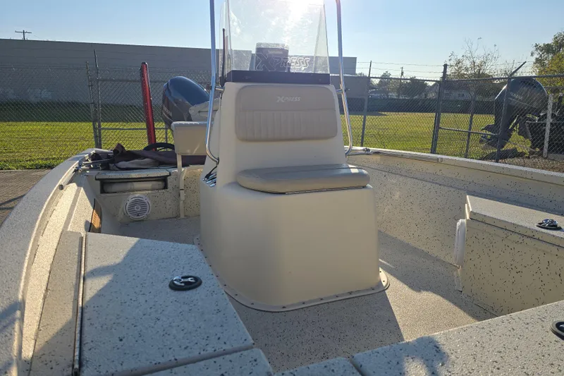 Slide: The Image of 2013 Xpress H20B Bay boat interior with seating and console, parked outdoors. - 6