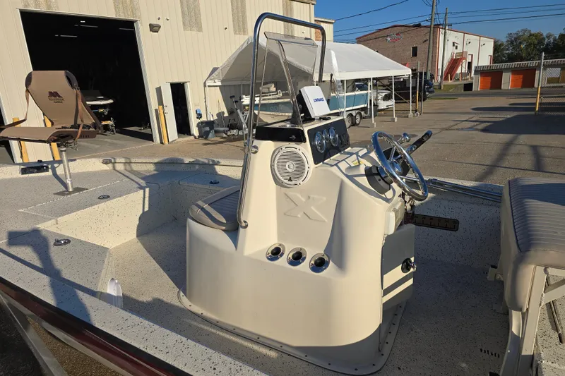 Slide: The Image of 2013 Xpress H20B Bay boat with steering console, parked outside a warehouse. - 8