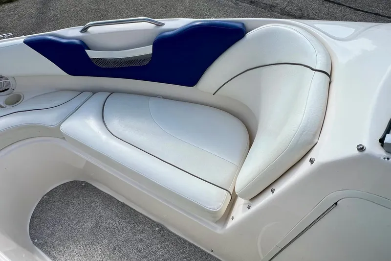 Slide: The Image of 2004 Rinker 232 Captiva Bowrider interior seating with white and blue upholstery. - 12