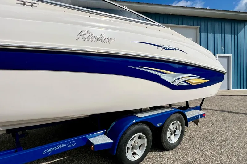 Slide: The Image of 2004 Rinker 232 Captiva Bowrider on trailer, parked outside blue garage. - 20