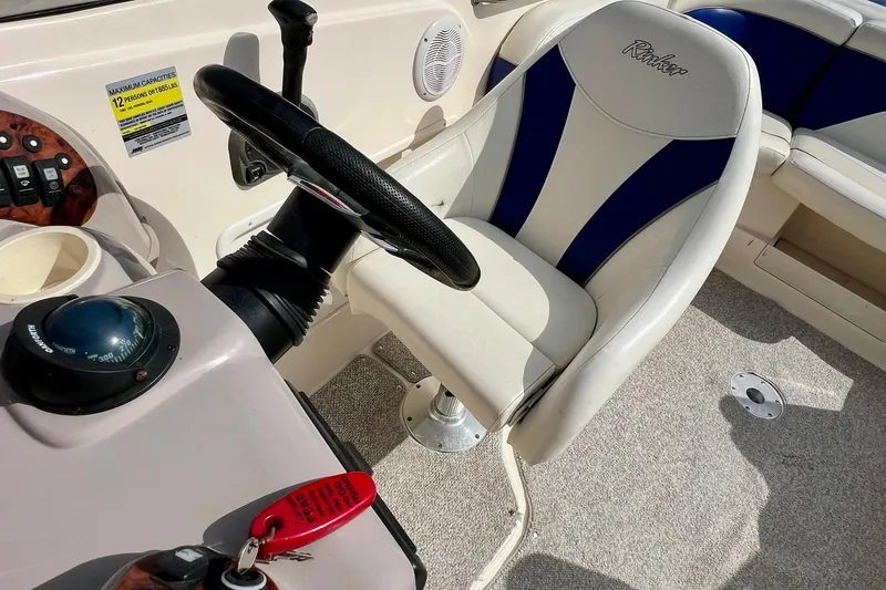 Slide: The Image of 2004 Rinker 232 Captiva Bowrider interior with blue and white seating. - 25