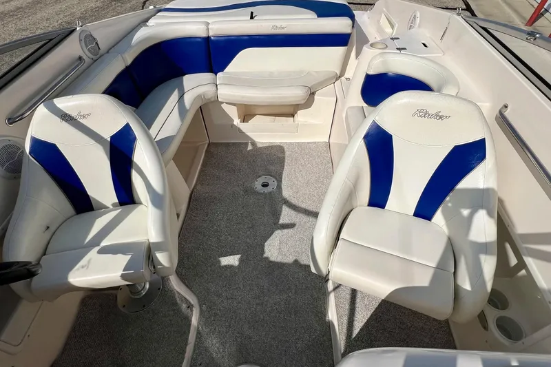 Slide: The Image of 2004 Rinker 232 Captiva Bowrider boat with sleek blue and white design. - 8