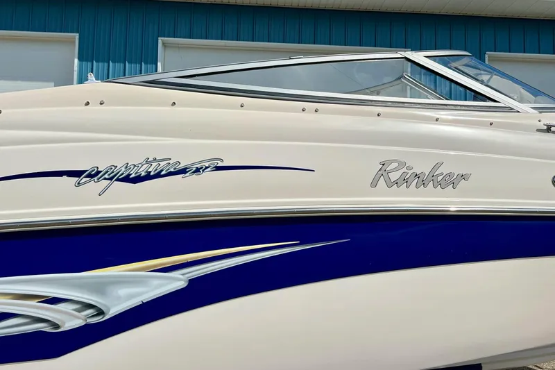 Slide: The Image of 2004 Rinker 232 Captiva Bowrider boat, blue and white design, rear view. - 9