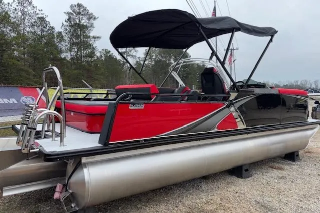 Slide: The Image of 2026 Tahoe Pontoon LTZ 2385 VRB Tritoon, red and black design, parked outdoors. - 5