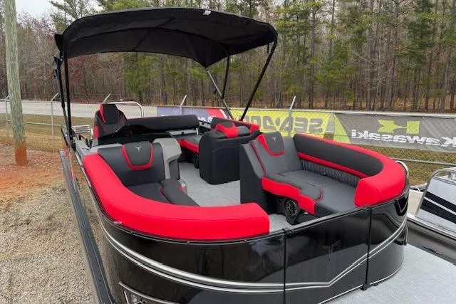 Slide: The Image of 2026 Tahoe Pontoon LTZ 2385 VRB Tritoon with red and black seating, parked outdoors. - 8