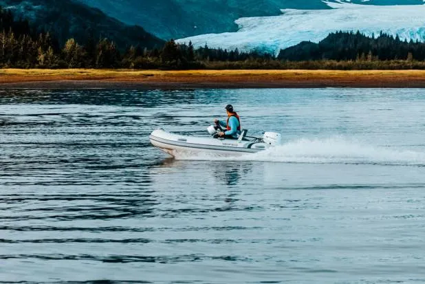 Slide: The Image of Manufacturer Provided Image: Person driving 2025 Highfield Classic 340 boat on scenic lake with mountains. - 11