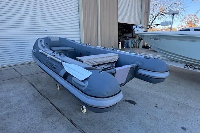Slide: The Image of 2025 Highfield Classic 340 inflatable boat on concrete near a garage. - 3