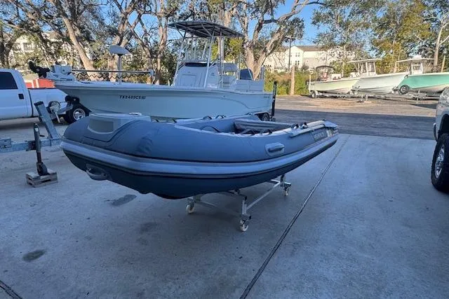 Slide: The Image of 2025 Highfield Classic 340 inflatable boat on a trailer in a marina setting. - 4