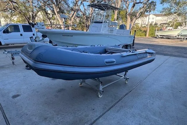 Slide: The Image of 2025 Highfield Classic 340 inflatable boat on a trailer in a marina setting. - 5