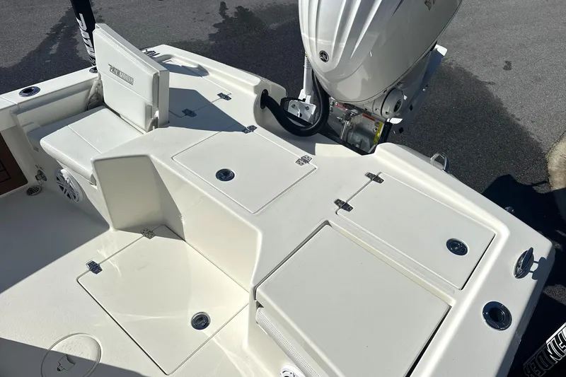 Slide: The Image of 2026 Pathfinder 2500 Hybrid boat deck with storage compartments and outboard motor. - 10