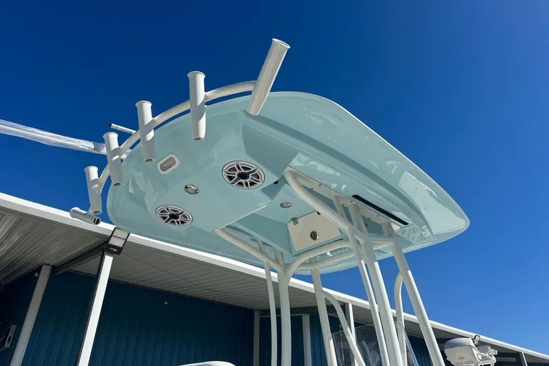 Slide: The Image of 2026 Pathfinder 2500 Hybrid boat top view with rod holders and speakers under clear blue sky. - 15