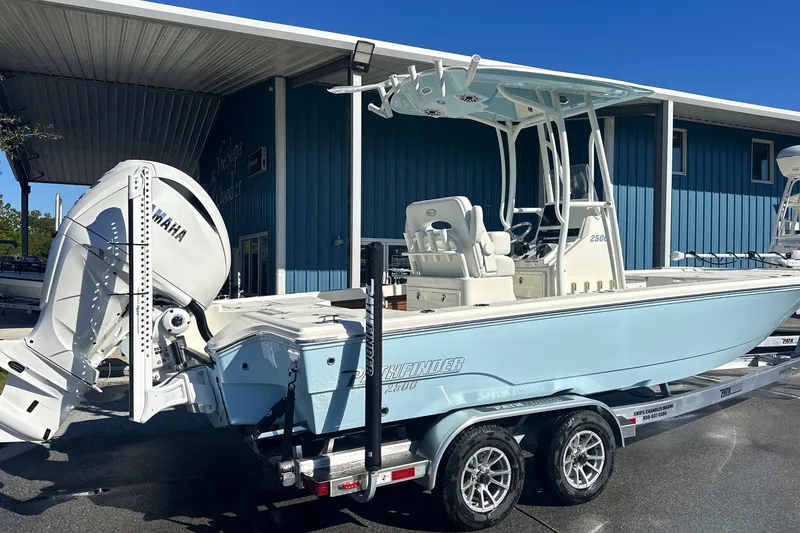 Slide: The Image of 2026 Pathfinder 2500 Hybrid boat with Yamaha engine on trailer, parked outside blue building. - 22