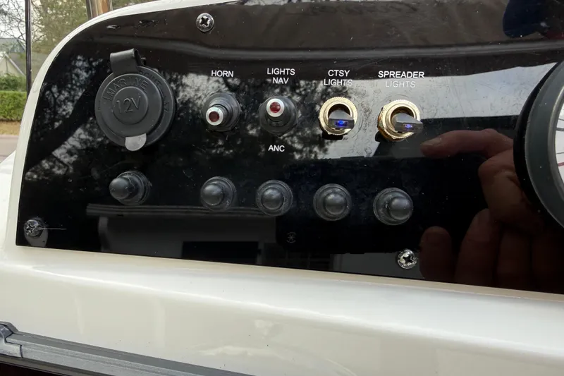 Slide: The Image of Control panel of 2021 Pioneer 202 Islander boat with switches and 12V outlet. - 13