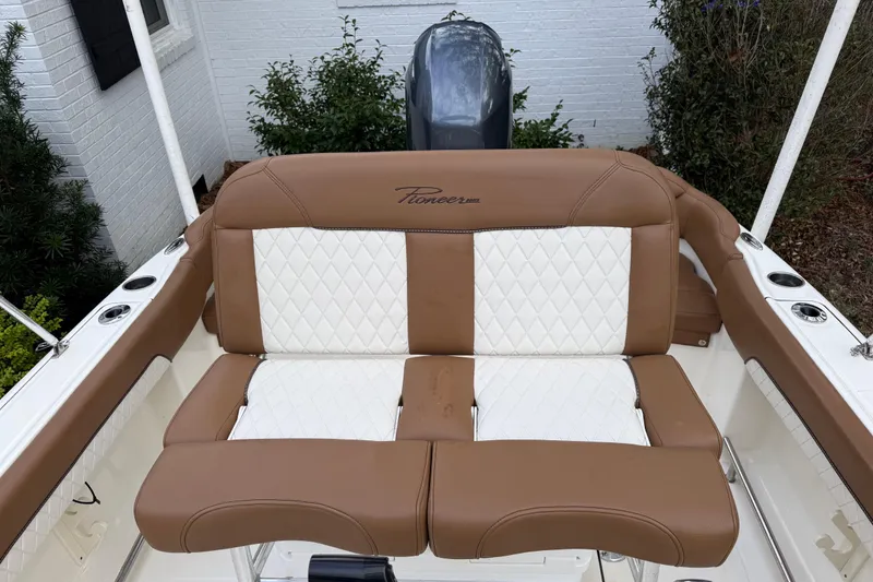 Slide: The Image of 2021 Pioneer 202 Islander boat seat with brown and white upholstery, outdoor setting. - 16