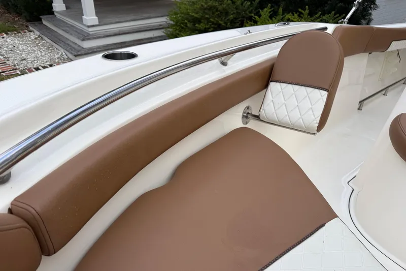 Slide: The Image of 2021 Pioneer 202 Islander boat interior with brown and white cushioned seating. - 21