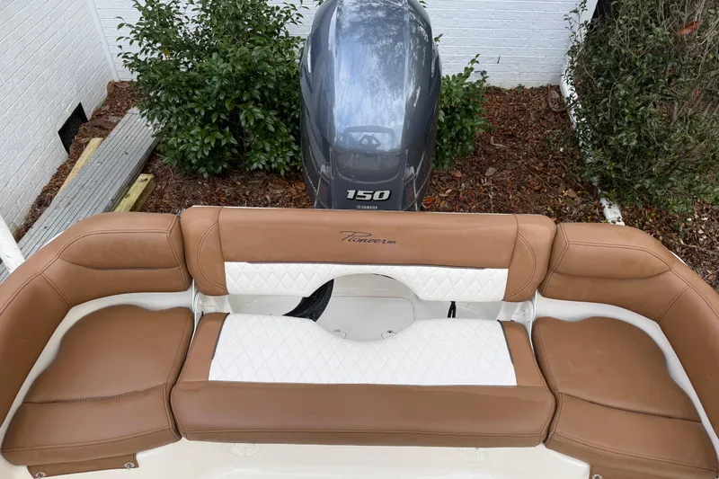 Slide: The Image of 2021 Pioneer 202 Islander boat with Yamaha 150 engine, featuring tan and white seating. - 22