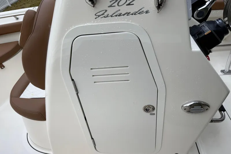 Slide: The Image of 2021 Pioneer 202 Islander boat console with brown seating and storage compartment. - 27