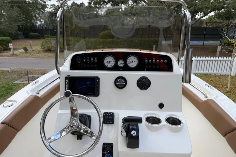 Slide: The Image of 2021 Pioneer 202 Islander boat dashboard with steering wheel, gauges, and navigation system. - 9
