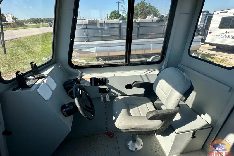 Slide: The Image of Interior of 2024 SeaArk 2672 Workhorse boat, featuring steering wheel and captain's chair. - 12
